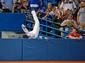 Blue Jays third baseman Josh Donaldson holds himself up after chasing a foul ball during second inning MLB action against the Rangers in Toronton on Saturday, June 27, 2015. (Nick Turchiaro/USA TODAY Sports)