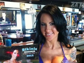 A waitress at the Texas restaurant Bikinis shows off the 2012 calendar in this photo from the restaurant's Facebook page. (Facebook)
