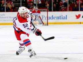 Mike Green #52 of the Washington Capitals takes a shot in the first period against the New Jersey Devils at Prudential Center on January 24, 2014 in Newark, New Jersey.  Elsa/Getty Images/AFP