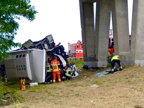 Rescuers stand next to a British bus, transporting 34 children and which overturned and crashed on a motorway, near the city of Middelkerke Belgium, June 28, 2015. REUTERS/Dominique Jauquet