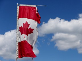 A tattered Canadian flag blows in the wind near a business on Bank Street on Friday June 26, 2015.   
Tony Caldwell/Ottawa Sun