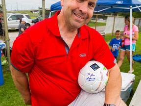 Jamie Fobert, manager of the Quinte Old Boys Soccer Club, proudly displays a soccer ball signed by NHL great Johnny Bower on Saturday in Belleville. Bower was at Zwick's Island signing autographs as part of the Old Boys skills development day. All proceeds from the fundraiser went towards local charities for autism. Tim Miller/The Intelligencer
