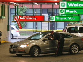 Police question people leaving the parking lot on Lisgar St where two men were murdered early Sunday morning. (MICHAEL PEAKE, Toronto Sun)