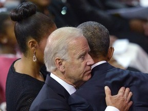 US Vice President Joe Biden (L) hugs US President Barack Obama after Obama delivered the eulogy during the funeral of Rev. and South Carolina State Sen. Clementa Pinckney, at the College of Charleston TD Arena, in Charleston, South Carolina on June 26, 2015. US President Barack Obama made a fresh pitch for tighter gun controls as he eulogized the pastor killed in the Charleston church shootings, saying Americans had ignored the toll of gun violence for too long. AFP PHOTO/MANDEL NGAN