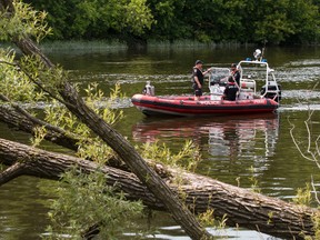 Members of the Ottawa Police Underwater Search and Recovery Unit work towards recovering the body of a man in the Rideau River in Ottawa. (Errol McGihon/Ottawa Sun/Postmedia Network)