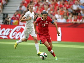 Canada forward Christine Sinclair (12) dribbles against England midfielder Jill Scott (8) during the second half in the quarterfinals of the FIFA 2015 Women's World Cup at BC Place Stadium. Matt Kryger-USA TODAY Sports
