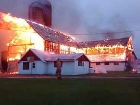 SUBMITTED PHOTO
Belleville firefighters continue to investigate a barn fire at 50 Denyes Rd., which sparked Sunday morning around 6 a.m. The barn was fully engulfed in flames and firefighters, fire prevention officers and a team of Ontario Fire Marshal investigators remained on the scene well into the evening Sunday. The origin and cause of the fire is unknown, as is the dollar loss, however, it's expected to be high. There were no injuries or fatalities as a result of the fire, but about 25 to 30 cows died.