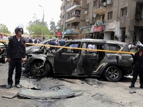 Policemen secure the site of a car bomb attack on the convoy of Egyptian public prosecutor Hisham Barakat near his house at Heliopolis district in Cairo, Egypt, on June 29, 2015. Barakat died from wounds sustained in a bomb attack on Monday that had targeted his convoy in Cairo, state news agency MENA said. (REUTERS/Mohamed Abd El Ghany)