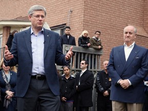Prime Minister Stephen Harper, left, is pictured in this April 7, 2011 file photo answering questions from the media as he tours the city of Vaughan, Ont. MP Julian Fantino is pictured to his right. (Veronica Henri/QMI agency)
