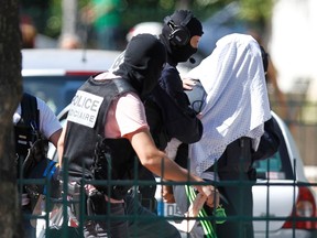 A man supposed to be suspect who held over an attack against a gas company site is escorted by police officers during investigations in Saint-Priest, near Lyon, France, June 28, 2015.  Yassin Salhi, 35, told detectives he had killed Herve Cornara in a parking area before arriving at the plant in Saint Quentin-Fallavier, 30 km (20 miles) south of Lyon, where he attempted to cause an explosion on Friday, the source told Reuters.  REUTERS/Emmanuel Foudrot