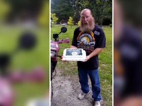 Chuck Netzhammer holds a cake with the image of an ISIS battle flag on it made by Walmart. (YouTube/Screengrab)