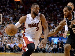 Heat guard Dwyane Wade (left) drives to the basket as Spurs forward Kawhi Leonard (right) defends during NBA action in San Antonio this season. (Steve Mitchell/USA TODAY Sports)