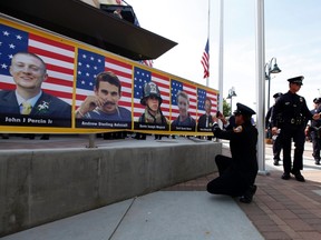 San Diego firefighter Robert Bunsoldat takes a picture of each of the Prescott Fire Department's Granite Mountain Hotshots team from a banner that circles the entrance to their memorial in Prescott Valley, Arizona July 9, 2013. Nineteen firefighters lost their lives when they became trapped and their position was overrun by flames from the Yarnell Hill Fire, southwest of Prescott on June 30, 2013.

REUTERS/Mike Blake