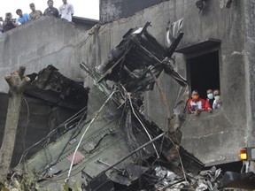 People view the wreckage of an Indonesian military C-130 Hercules transport plane after it crashed into a residential area in the North Sumatra city of Medan, Indonesia, June 30, 2015, in this photo taken by Antara Foto. More than 100 people were feared dead after the military transport plane ploughed into a residential area shortly after take-off in northern Indonesia on Tuesday, in what may be the deadliest accident yet for an air force with a long history of crashes. REUTERS/Irsan Mulyadi/Antara Foto