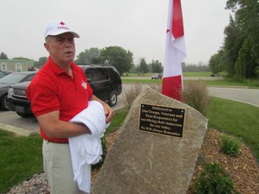 Gus Pantazis, owner of Global Donuts and Deli on London Road, unveils a stone at the business commemorating first responders and veterans on Tuesday June 30, 2015 in Sarnia, Ont. (Sarnia Observer)