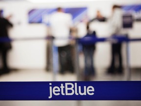 Customers check in at a JetBlue Airways counter. The airline will now charge up to $25 for checked luggage (REUTERS/Lucas Jackson)