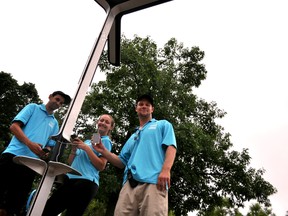 Aiden McGlynn (left), Olivia Wassing and DJ Adams, members of the Downtown London Clean Team, use the new solar powered device charging station at the corner of Central Avenue and Richmond Street in London Ont. June 30, 2015. CHRIS MONTANINI\LONDONER\POSTMEDIA NETWORK
