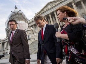 Rep. Thomas Massie, left, listens as Sen. Rand Paul, right, speaks to reporters after exiting the Senate chamber, on Capitol Hill, May 31, 2015 in Washington, DC. After the NSA's authority to collect bulk telephone data was left in legal limbo despite the recent creation of the Freedom Act, a U.S. court has ruled that the NSA can resume eavesdropping on Americans temporarily. Drew Angerer/Getty Images/AFP