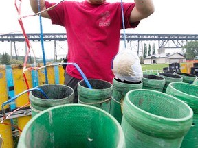 Pyrotechnician Rod Nagata loads fireworks as crews prepare for Canada Day in Walterdale Park, in Edmonton Alta. on Tuesday June 30, 2015. David Bloom/Edmonton Sun/Postmedia Network