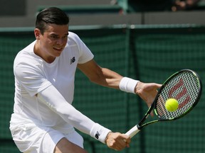 Milos Raonic of Canada returns a shot to Tommy Haas of Germany during their singles match at the All England Lawn Tennis Championships in Wimbledon, London, Wednesday July 1, 2015. (AP Photo/Tim Ireland)