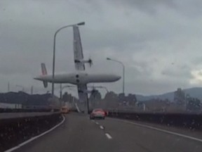 A still image taken from an amateur video shot by a motorist shows a TransAsia Airways plane cartwheeling over a motorway soon after the turboprop ATR 72-600 aircraft took off in New Taipei City February 4, 2015. The TransAsia Airways plane with 58 passengers and crew on board cartwheeled into a river shortly after taking off from a downtown Taipei airport.  REUTERS/AMVID via Reuters TV