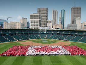Thousands of Winnipeggers dressed in red and white shape a human flag at Shaw Park for Canada Day 2015. (Downtown Winnipeg BIZ photo)