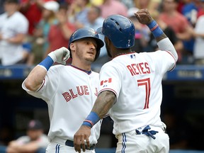 Toronto Blue Jays shortstop Jose Reyes, right, greets third baseman Josh Donaldson after scoring on a home run by Donaldson against Boston Red Sox in the eighth inning at Rogers Centre. The Jays won 11-2. (Dan Hamilton-USA TODAY Sports)