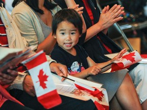 Three-year-old Jacqueline Zhang cheers on her parents as they become Canadian citizens at the Canada Day citizenship court held in Memorial Hall at City Hall in Kingston, Ont. on Wednesday, July 1, 2015. Julia McKay/The Kingston Whig-Standard/Postmedia Network