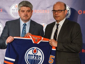 Oilers President of Hockey Operations and General Manager Peter Chiarelli (right) hands new head coach Todd McLellan an Oilers jersey after announcing his hiring in Edmonton on May 19, 2015. (Codie McLachlan/Postmedia Network)