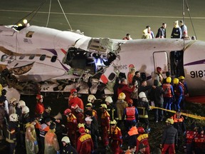 Rescuers search inside the wreckage of a TransAsia Airways turboprop ATR 72-600 aircraft after it was recovered from a river, in New Taipei City, February 4, 2015. The TransAsia Airways plane with 58 passengers and crew on board careered into a river shortly after taking off from a downtown Taipei airport on Wednesday, killing 23 people and leaving 20 missing, officials said. REUTERS/Pichi Chuang