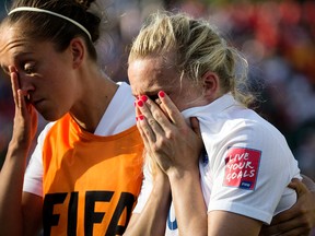 England's Josanne Potter (left) consoles Laura Bassett (right) following England's 2-1 loss to Japan during FIFA Women's World Cup semifinal action at Commonwealth Stadium in Edmonton on Wednesday, July 1, 2015. (David Bloom/Postmedia Network)