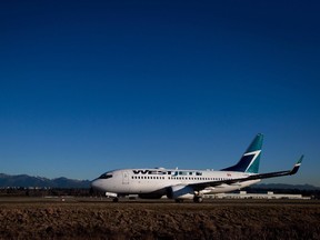 A Westjet Boeing 737-700 taxis to a gate after arriving at Vancouver International Airport in Richmond, B.C., on Monday February 3, 2014. For the fourth time in less than a week, a Canadian passenger jet has had to make an emergency landing because of a threat made against it. 
THE CANADIAN PRESS/Darryl Dyck