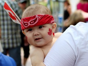Happy 148th Birthday Canada! A very cute, chubby cheeked and obviously proud Canadian toddler is carried through the ground during the City Hall Canada Day celebrations on July 1, 2015. Hugo Sanchez/Special to the Edmonton Sun