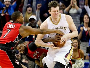 New Orleans Pelicans center Omer Asik (3) secures a rebound over Toronto Raptors forward Amir Johnson (15) and guard Kyle Lowry (7) during the fourth quarter of a game at the Smoothie King Center. The Pelicans defeated the Raptors 100-97. (Derick E. Hingle-USA TODAY Sports)