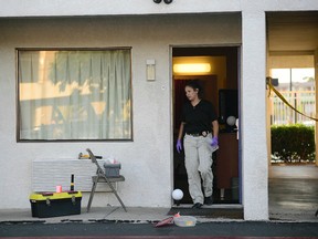 An Albuquerque Police Department officer collects evidence on July 1, 2015, after a man was killed and another injured during what police say was an altercation between the two late Tuesday at a Motel 6 in Albuquerque, N.M. (Adolphe Pierre-Louis/Albuquerque Journal via AP)
