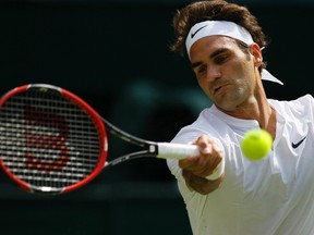 Roger Federer returns a ball to Sam Querrey during their Wimbledon singles match in London Thursday, July 2, 2015. (AP Photo/Pavel Golovkin)