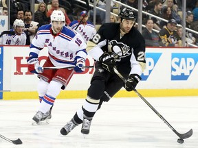 Pittsburgh Penguins right wing Daniel Winnik (26) skates with the puck ahead of New York Rangers center Derick Brassard (16) during the second period in game four of the first round of the 2015 Stanley Cup Playoffs at the CONSOL Energy Center April 22, 2015. (Charles LeClaire-USA TODAY Sports)