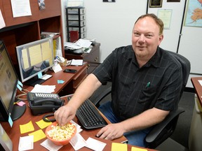 In this June 16, 2015 photo, Zoovio co-owner Marlo Anderson eats popcorn at his desk at his Mandan, N.D. business. Anderson says he started an online compendium of special days in 2013 called National Day Calendar after his love of popcorn piqued his curiosity about National Popcorn Day (Jan. 19). (AP Photo/Will Kincaid)