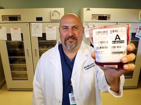 Luke Hendry/The Intelligencer
Chief surgeon Dr. Sean McIlreath holds a unit of red blood cells in front of the Belleville General Hospital laboratory's blood bank Thursday. A single surgery can use multiple units of blood, but there's a shortage of donors. Ontario donors provide 40 per cent of Canadian Blood Services' national supply.