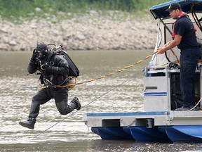 A Winnipeg police diver leaps into the Red River in Winnipeg, Man. Thursday July 02, 2015. Police are searching the river at the end of Burrows Avenue investigating suspicious circumstances.