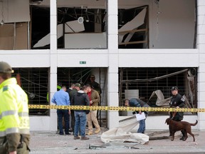 Police officers inspect an office after it was wrecked by an explosion in Bogota, Colombia, Thursday, July 2, 2015. A homemade explosive device went off in the financial district of Colombia's capital and wounded several people, while a second blast elsewhere in Bogota injured another, authorities said. (AP Photo/Fernando Vergara)