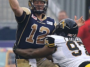 Winnipeg Blue Bombers QB Brian Brohm has his throw forced by Hamilton Tiger-Cats DT Ted Laurent during CFL action in Winnipeg on Thu., July 2, 2015. Kevin King/Winnipeg Sun/Postmedia Network