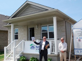 Habitat for Humanity – Heartland Ontario CEO Jeff Duncan, left, speaks in front of the first-ever Habitat home in St. Thomas at a dedication ceremony last May. Standing with Duncan is Habitat past chairman Phil Squire.