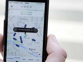 A file photo taken on June 17, 2015 shows a person using the French version of the Uber app to order a UberPop cab in Paris. (AFP PHOTO/THOMAS OLIVA)
