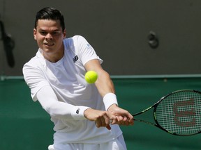 Milos Raonic returns a ball to Nick Kyrgios during their Wimbledon match at the All England Club in London Friday July 3, 2015. (AP Photo/Tim Ireland)