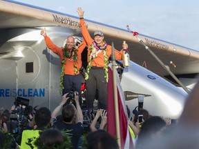 Solar Impulse 2 pilot Bertrand Piccard(L) and pilot Andre Borschberg, celebrate after Borschberg landed at Kalaeloa Airport, Hawaii, on July 3, 2015. Solar impulse 2 is attempting to be the first solar powered airplane to fly around the world without using fuel. The airplane took off from Nagoya Japan on its eighth leg and flew non-stop before landing on Oahu.  The revolutionary Solar Impulse 2 aircraft completed an historic flight Friday after circling the globe without so much as a drop of fuel, then touching down seemingly effortlessly in Hawaii. The sun-powered plane, piloted by veteran Swiss aviator Andre Borschberg, spent five days to make the historic voyage, landing shortly after dawn at Kalaeloa Airport on the main Hawaiian island of Oahu. AFP PHOTO / EUGENE TANNER