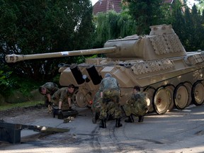 In this July 2, 2015 picture a  World War II -era Panther  tank  is prepared  for transportation from a residential property in Heikendorf,  northern Germany.  Authorities have seized a 45-ton Panther tank, a flak canon and multiple other World War II-era military weapons in a raid on a 78-year-old collector's storage facility in northern Germany. Kiel prosecutor Birgit Hess said the collector is being investigated for possibly violating German weapons laws but his attorney Peter Gramsch told the dpa news agency all the items were properly demilitarized and registered.  (Carsten Rehder/dpa via AP)