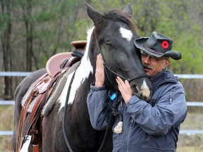 Roger Boudreau, a London native who suffers from post-traumatic stress disorder hugs a horse named Dakota during an equine therapy session in Pembroke. Ont.  (Shannon Lough, Special to The Free Press)