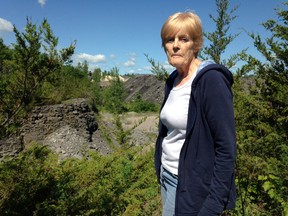 Mary Rahmel stands on property in Elginburg with the limestone quarry in the background. (Paul Schliesmann/The Whig-Standard)