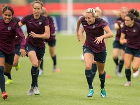 England's Toni Duggan (R) races with her teammates during their final training session before Saturday's bronze medal match against Germany. (Geoff Robins, AFP)